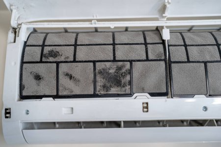 Dirty air conditioner filter in dust, untimely cleaning, maintaining and service of appliance. Cause of allergy to dust, respiratory damage, exacerbation of asthma symptoms. Filter replacement.