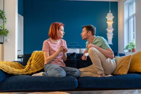 Photo for Upset married couple sit on couch arguing. Excited quarrel, family relations communication problem. Frustrated sad wife talk about relationship problems with husband, crisis conflict misunderstanding - Royalty Free Image