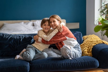 Photo for Little kid boy cuddling older sister at home. Happy American siblings hugging embracing feeling love, care, connection. European family showing love. Small brother with teen girl in closes relations. - Royalty Free Image