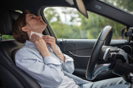 Photo for Woman drives car with broken air conditioning in hot summer weather wipes sweat paper napkin. Middle aged female suffering from heat stuffiness. Tired exhausted overheated stressed worried driver. - Royalty Free Image