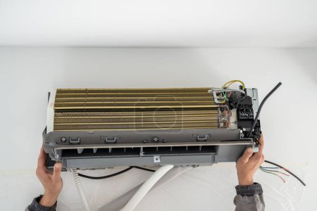 Photo for Installation air conditioning system on white wall in apartment, office closeup. Technology inverter air conditioning system in apartment. Ventilation replacement in house. Controlling temperature - Royalty Free Image