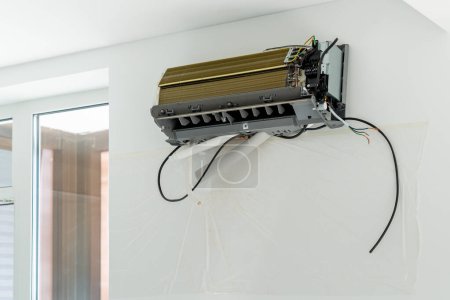 Téléchargez les photos : Installation système de climatisation sur mur blanc dans l'appartement, gros plan de bureau. Technologie onduleur système de climatisation dans l'appartement. Remplacement de la ventilation dans la maison. Contrôle de la température - en image libre de droit