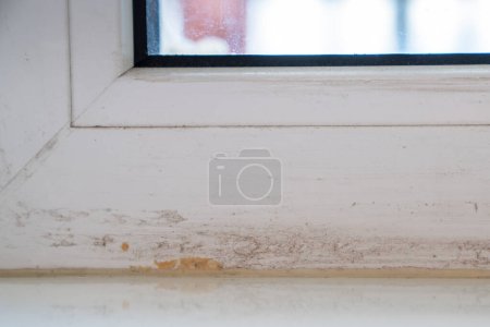 Photo for Part of dirty window frame after installing plastic windows and removing duct tape. Need special cleaners for difficult stains. Damaged frames with glue residue plaque on surface after renovation. - Royalty Free Image