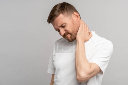 Photo for Unhealthy man suffering painful neck ache after sports exercise. Guy rubbing muscles to relieve pain or nerve spasm. Back pain and hernia, sedentary lifestyle concept. Health problems after 40. - Royalty Free Image