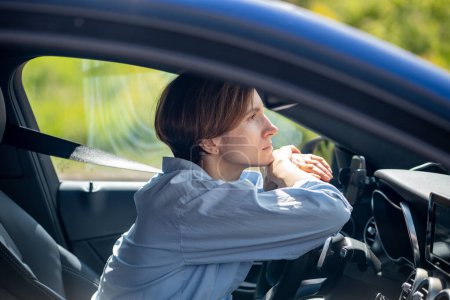 Photo for Pensive serious woman standing in traffic jam waiting driving car looking ahead. Calm thoughtful female sitting in car fastened with safety belt folding hands on steering wheel. Urban road problems. - Royalty Free Image