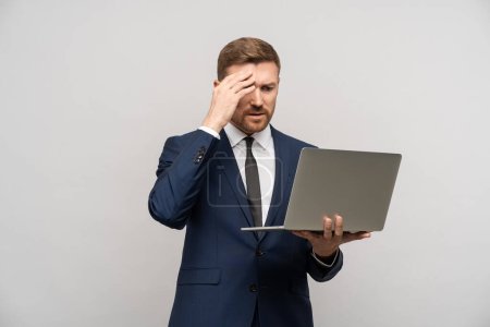 Frustrated businessman with laptop in hands. Worried trader man failed on stock exchange failed in trading, falling sales, business collapse, difficulties financial problems, burnt investments