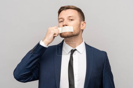 Photo for Man office worker with tape on his mouth. Office employee not ready to tolerate prohibitions to express opinion, dissatisfaction with strict system, office hierarchy, ban on freedom of speech concept - Royalty Free Image
