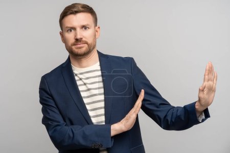 Photo for Frustrated man with disgust on serious face incredulously pushes away troubles with gesture of hands isolated on gray background. Male with angry expression refuse something bad showing denial. - Royalty Free Image