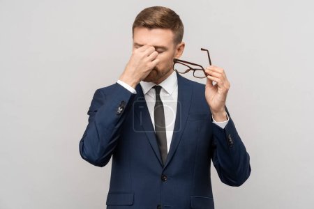 Photo for Tired businessman takes off glasses, massaging eyelids of eyes. Caucasian exhausted office worker wipes tired aching eyes. Overworked employee, fatigue, need to rest your eyes, decreased vision - Royalty Free Image