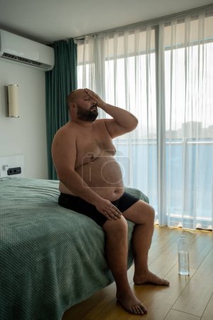 Photo for Fat guy suffers tortures from excessive sweating heat stuffiness summer abnormally high temperatures. Sweating due to obesity. Problems diseases excess weight entails diabetes knocking down hormones. - Royalty Free Image