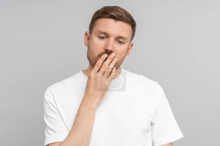 Photo for Sleepy yawning man with closed eyes opened mouth covering hand on gray background. Portrait of exhausted tired bored handsome guy. Lack of energy, sleeplessness at night, early awakenings concept. - Royalty Free Image