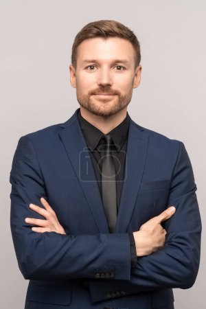Photo for Successful trader man in business suit on studio gray background. Caucasian bearded young man folded arms over chest. Manager, director of company, successful businessman, investor, influential person - Royalty Free Image