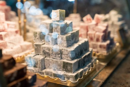 Photo for Turkish delight behind glass of restaurant window. Confectionery starch and sugar product from eastern country along with variety of delicious fruity colored candies, cakes and sweets in buffet cafe - Royalty Free Image