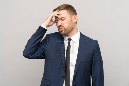 Photo for Tired confused frustrated businessman wears in official suit with dissatisfied face isolated studio background. Man touching forehead in tense thoughtful emotional state. Burnout, problem concept. - Royalty Free Image