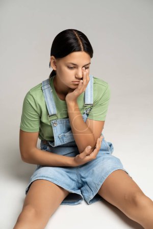 Photo for Depressed teen girl upset with harassment, pressure, offense, bullying from classmates at school, conflicts in family, broken relations with boyfriend. Desperate girl thinks over problem solution - Royalty Free Image