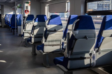 Foto de Interior of modern passenger high-speed express train, row of empty blue fabric soft seats selective soft focus. Inside the train carriage with comfortable and colorful chairs. Public transportation - Imagen libre de derechos