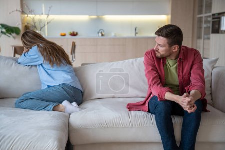 Photo for Couple relations, man woman offended each other. Wife crying turning away sitting on couch, husband talking with her. Relationships crisis, marital discord, family quarrel, offended spouses concept. - Royalty Free Image