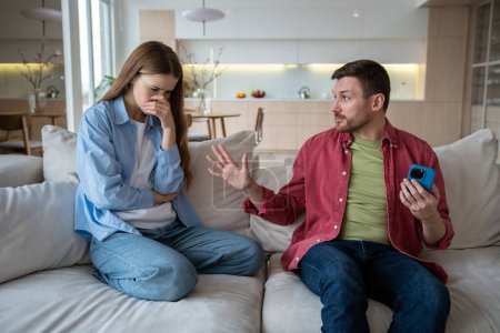 Man woman quarrel over internet addiction and hanging in phone long time. Tired upset wife asking husband take his mind off smartphone. Marital discord, couple relationships, emotional conversation.