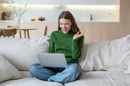 Photo for Happy woman winner trader, crypto investor, entrepreneur, financier freelancer looking at laptop screen rejoicing sitting on couch at home. Having goal, achievement at work. Digital nomad, freelance. - Royalty Free Image