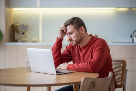Photo for Disappointed hopeless unemployed middle aged man jobseeker sitting at table, reading advertisements on web sites, looking through vacancies, hunting for job. Depressed man after dismissal, job cut - Royalty Free Image