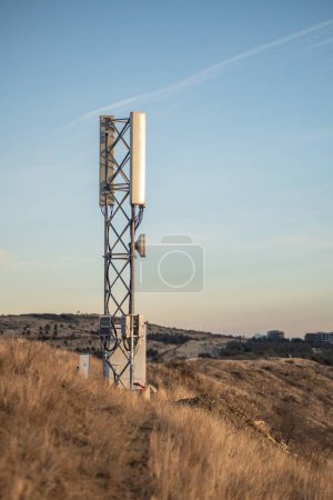 Foto de Célula torre 5G en montañas, estación base celular con antena móvil transmite señales, extensión de cobertura. Nuevas tecnologías, comunicaciones por satélite, Internet en lugares de difícil acceso. - Imagen libre de derechos