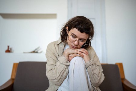 Photo for Tired depressed desperate tired teen girl sadly sitting on couch at home. Upset teenager boring. Nervous schoolgirl feels frustration hiding from society in loneliness solitude. Psychological problem - Royalty Free Image