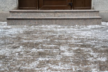 Photo for Icy sidewalk. Ice crust in front of building entrance, sidewalk tile covered with ice selective soft focus, slippery street. Winter weather. - Royalty Free Image
