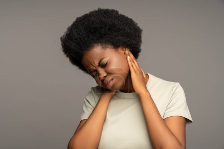 Unwohlsein Afroamerikanerin leidet an Osteochondrose, Muskelkrämpfen, Krämpfen, eingeklemmten Nerven. Kranke Frau berührt Reiben massiert schmerzhaften Nacken Gefühl Unbehagen, Schmerzen, Schmerzen nach plötzlicher Bewegung