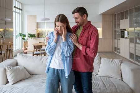 Caring man tenderly hugs frustrated upset wife in living room. Unhappy woman finds comfort in husband hugs. Relationship married couple is based on love care, trust. Family support in troubles moment.