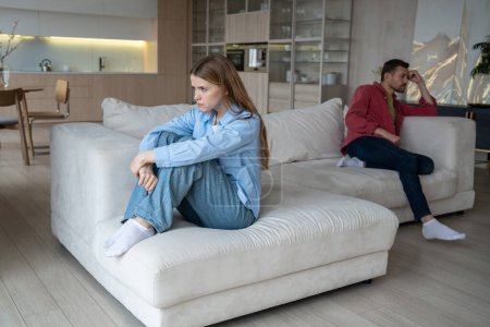 Unzufriedene Männer und Frauen streiten sich auf einem großen Sofa zu Hause, wobei sich beide den Rücken zugedreht haben. Ernsthafter Konflikt für Familienpaar, das nach Schwierigkeiten Beziehung aufbaut. Liebesprobleme aus Missverständnissen