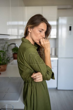 Photo for Thoughtful worried woman putting hand to mouth reflecting pondering about problem at home. Depressed upset apathetic stressful female busy thinking about troubles, received bad news sadly looking down - Royalty Free Image