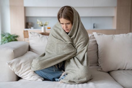 Photo for Desperated depressed woman crying sitting on couch with closed eyes wrapped in plaid. Girl suffering fom emotional pain having life troubles problems. Mental disorder, anhedonia, stress, sleepiness. - Royalty Free Image