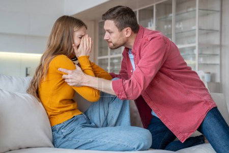 Foto de Man tyrant husband beating crying wife during scandal misunderstanding at home. Stressed mad abuser mocks the victim. Domestic physical emotional violence, toxic relationship, marital discord concept. - Imagen libre de derechos