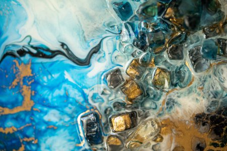 Closeup of epoxy resin with natural minerals, crystals and stones, painting of geode mixing vibrant pigments and colors. Texture of epoxy resin effect. Modern abstract liquid fluid art. 
