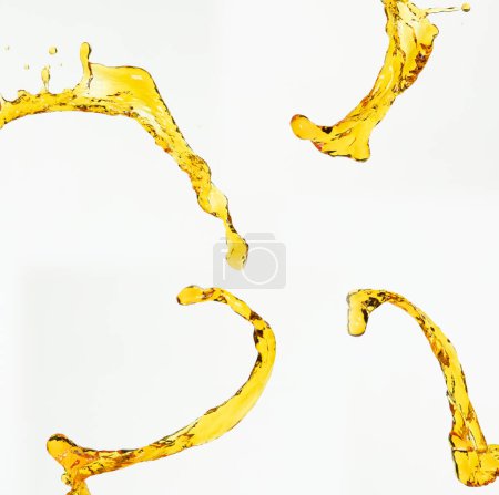 Photo for Orange, lemon juice or oil lubricant splash, liquid gold yellow drink drops. Fruit beverage water elements in line form . Fresh splashing and flowing jets, white background isolated freeze motion - Royalty Free Image