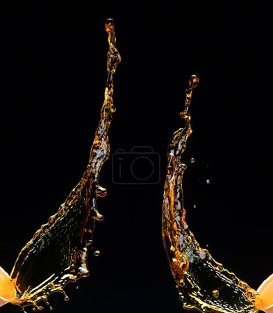 Foto de Naranja, zumo de limón o aceite lubricante salpicadura, gotas de bebida amarilla de oro líquido. Elementos de agua de bebidas de frutas en forma de línea. Salpicaduras frescas y chorros que fluyen, fondo negro aislado movimiento de congelación - Imagen libre de derechos