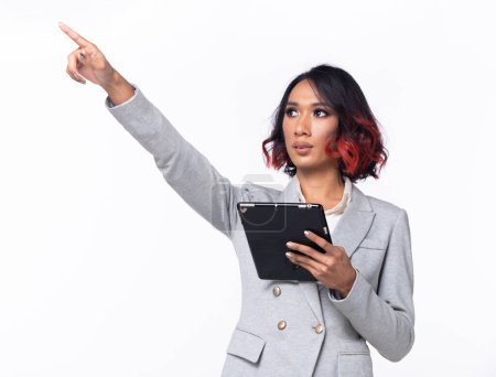 Photo for Half body Tanned skin Asian Indian woman points finger hand up to Sky, Business Blazer female has confident smart hold tablet to future empty area air, studio white background isolated - Royalty Free Image