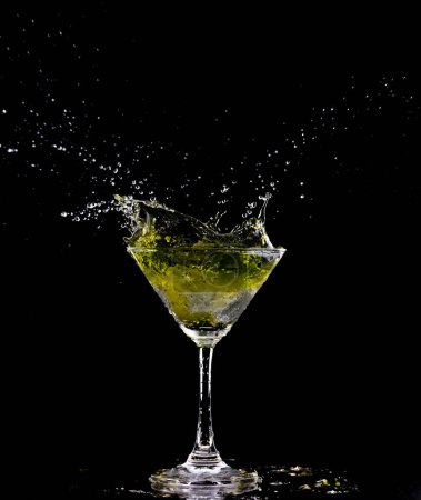 Photo for Yellow Cocktail Glass with splashing water alcohol, Crystal Cocktail drink splatter splash in air and bubble from glass. Liquor Part freeze shot high speed over black background isolated - Royalty Free Image