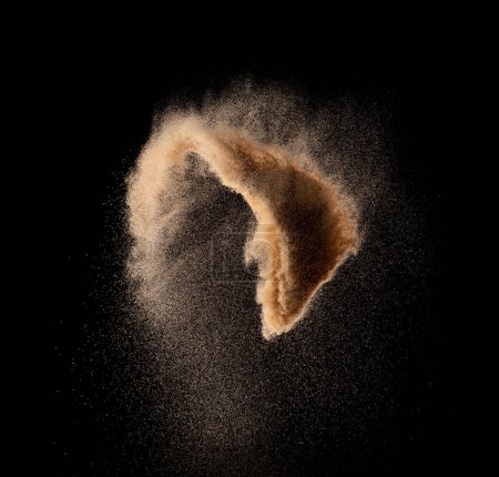 Foto de Explosión de vuelo de arena fina de pequeño tamaño, explosión de onda de grano dorado. Nube abstracta vuela. Arena de color amarillo salpicadura de sílice en el aire. Fondo negro Obturador de alta velocidad aislado, lanzamiento de disparo de congelación - Imagen libre de derechos