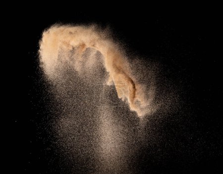 Foto de Explosión de vuelo de arena fina de pequeño tamaño, explosión de onda de grano dorado. Nube abstracta vuela. Arena de color amarillo salpicadura de sílice en el aire. Fondo negro Obturador de alta velocidad aislado, lanzamiento de disparo de congelación - Imagen libre de derechos