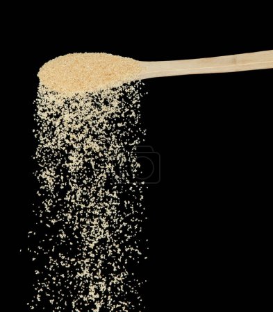 Photo for Brown Sugar fall, brown grain sugar pouring down abstract cloud fly from wooden spoon. Beautiful complete seed sugarcane, food object design. Selective focus freeze shot Black background isolated - Royalty Free Image