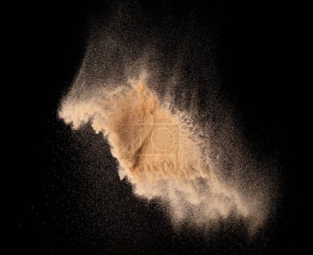 Foto de Explosión de vuelo de arena fina de pequeño tamaño, explosión de onda de grano dorado. Nube abstracta vuela. Arena de color amarillo salpicadura de sílice en el aire. Elemento Fondo negro Aislado de alta velocidad lanzando tiro de congelación - Imagen libre de derechos