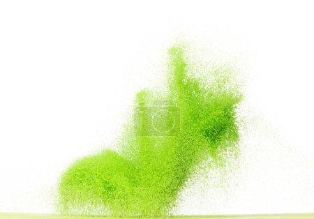 Foto de Explosión voladora de arena verde de pequeño tamaño, onda de grano de arenas vegetales explotan. Nube abstracta vuela. Salpicadura de arena de color verde lanzando en el aire. Fondo blanco Obturador aislado de alta velocidad, congelación de lanzamiento - Imagen libre de derechos