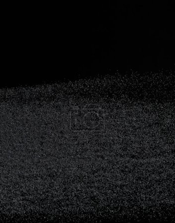 Téléchargez les photos : Million of black sand explosion, Photo image of falling down sands flying. Freeze shot on black background isolated overlay. Tiny Fine sand dust magnet as particle disintegrate science - en image libre de droit