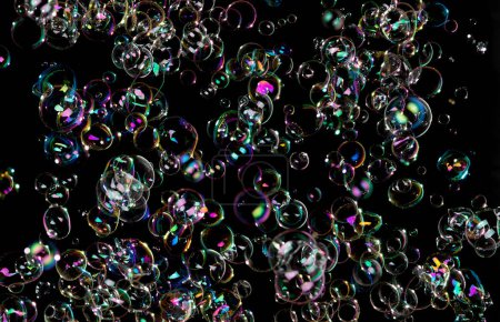 Téléchargez les photos : Soap Bubble fly on Black background. Many shampoo bubbles float in Air. Group of soap bubble with colorful rainbow on surface reflection to light create abstract texture - en image libre de droit