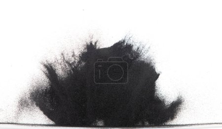 Foto de Explosión voladora de arena negra de pequeño tamaño, explosión de grano de arena de polvo de carbono. Nube abstracta vuela. Salpicadura de arena de color negro lanzando en el aire. Fondo blanco Obturador aislado de alta velocidad, congelación de lanzamiento - Imagen libre de derechos