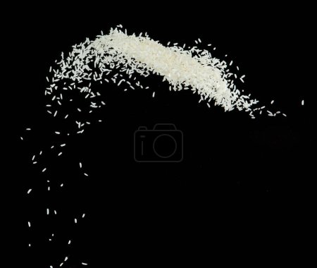 Foto de Explosión voladora de arroz japonés, los arroces de grano blanco explotan la nube abstracta vuela. Hermosa semilla completa salpicadura de arroz en el aire, diseño de objetos alimenticios. Congelación de enfoque selectivo tiro Fondo negro aislado - Imagen libre de derechos