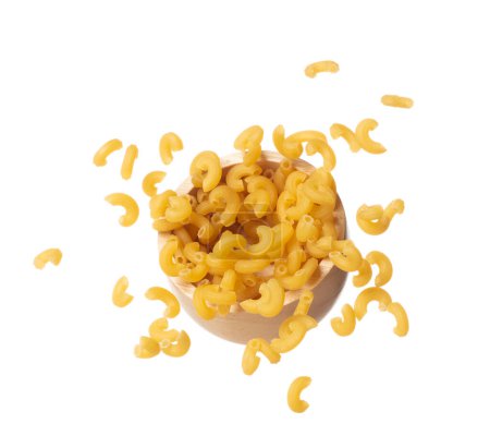 Téléchargez les photos : Macaroni fall on wooden bowl, yellow macaronis pasta float explode, abstract cloud fly. Curved macaroni pasta splash throwing in Air. White background Isolated high speed shutter, freeze motion - en image libre de droit