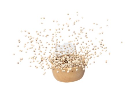 Foto de White Pepper seeds fall down pour in wooden bowl, white Pepper float explode, abstract cloud fly. Peppercorn splash throwing in Air. White background Isolated high speed shutter, freeze motion - Imagen libre de derechos
