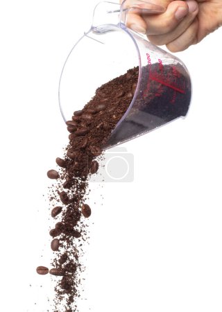 Foto de Coffee powder mix bean fall down pour in measured cup, Coffee crushed mix seed float explode, abstract cloud fly. Coffee dust powder bean splash throwing in Air. White background Isolated high speed - Imagen libre de derechos